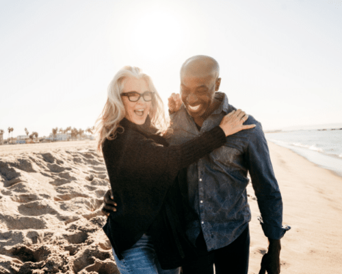 Happy older couple strolling on the beach. About Retirement Planning Concept.