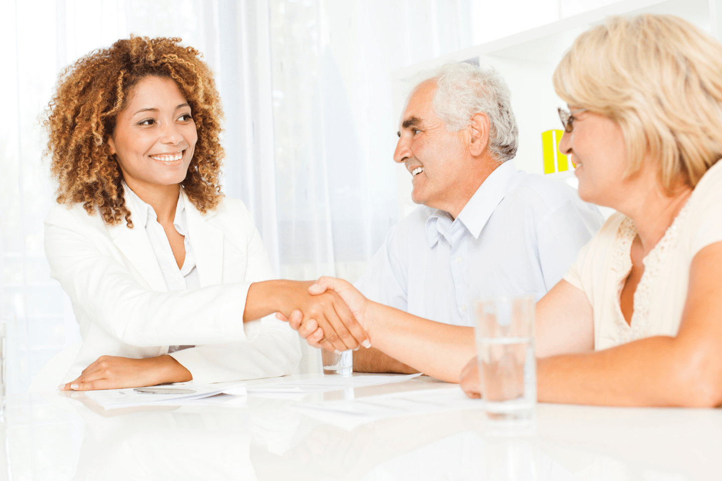 Senior couple meeting with financial advisor and agreeing on the development of a financial plan. Comprehensive Financial Planning Concept.