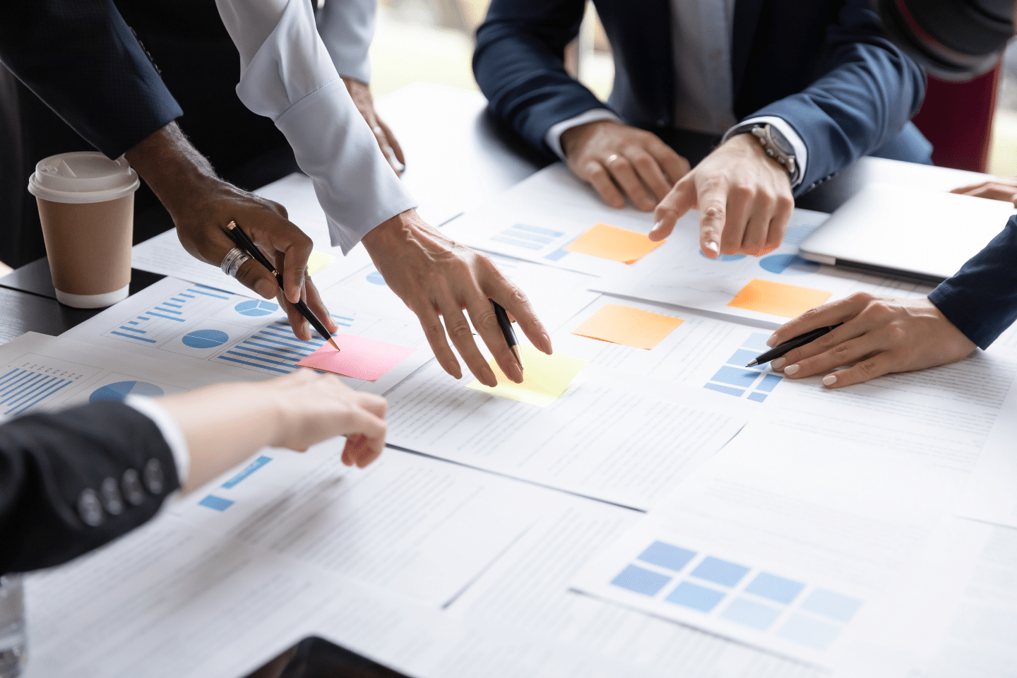 Financial planner hands at work at a conference table pouring over spreadsheets. Visualizes the concept of the financial planning process