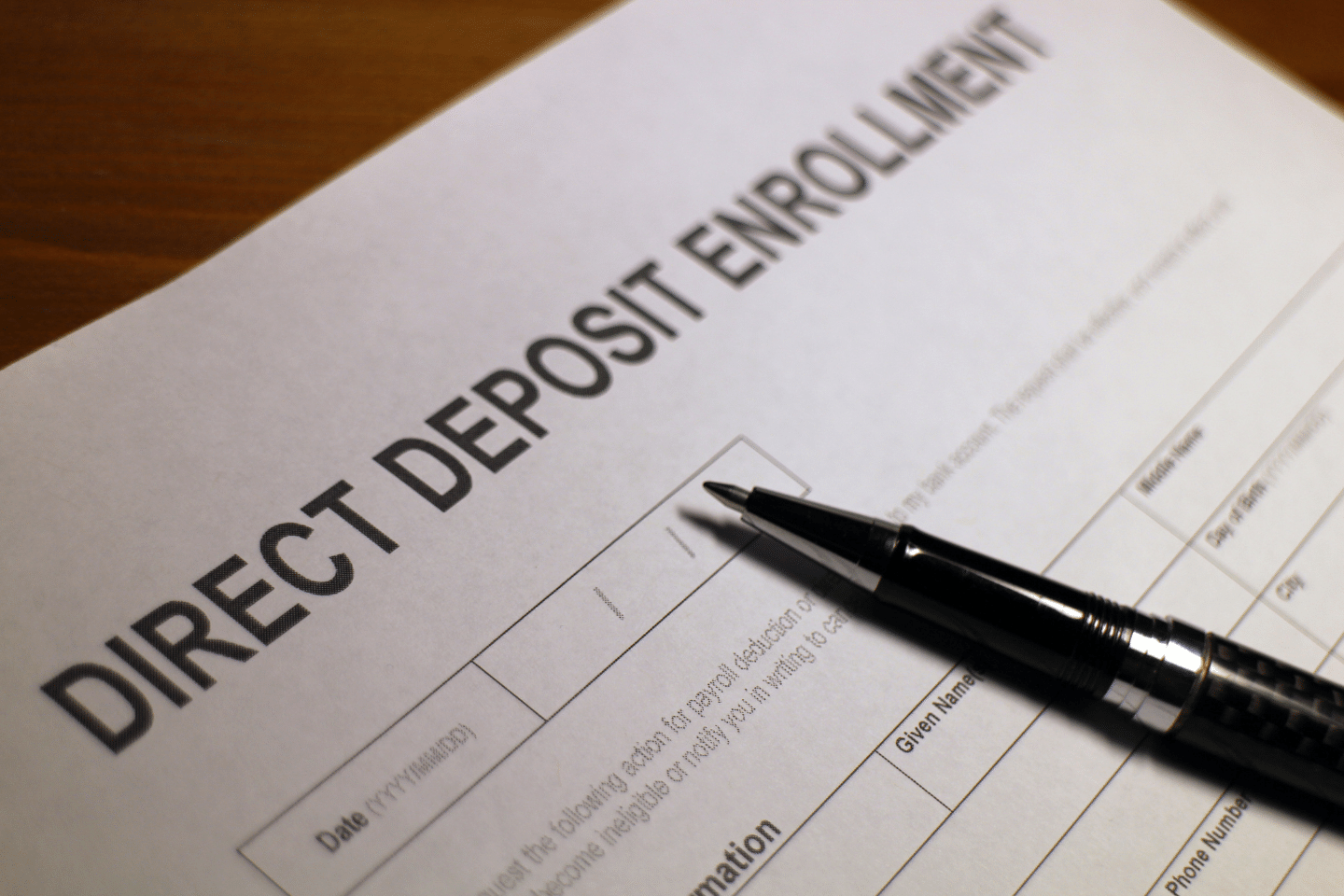 Direct Deposit Enrollment: Person filling out a direct deposit enrollment form. Save More Money Concept