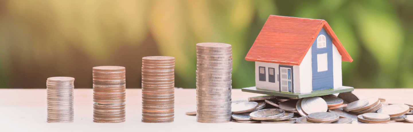 View of Coin Stack with House Model on Green Background. Equity Concept.