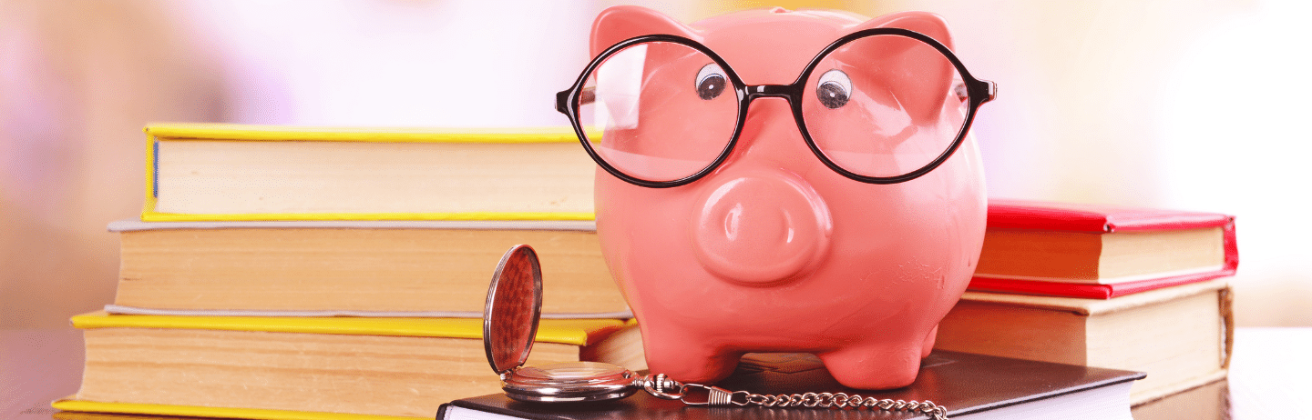 Financial Literacy Concept with Piggy Bank, Eyeglasses, Pocket Watch, and Books