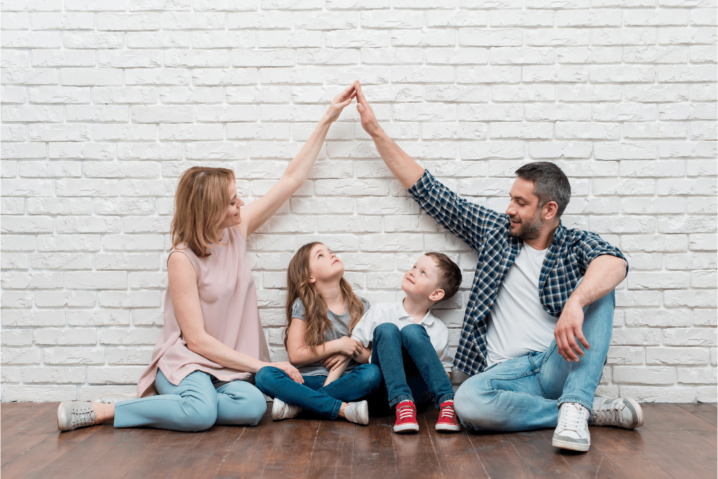 Home. House. Family.: Couple holding hands to form a roof above their boy and girl. Insuring Concept.